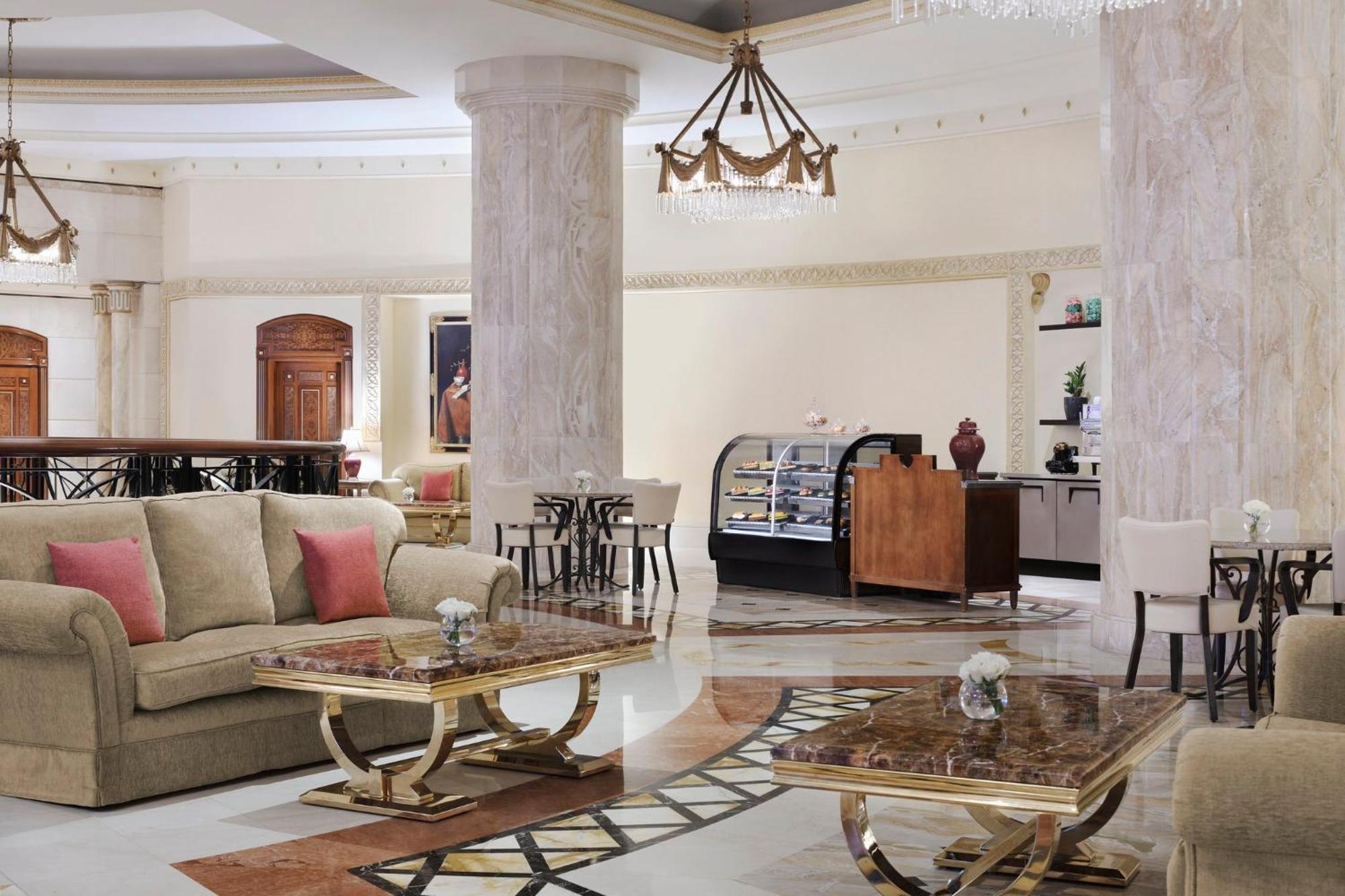 Intercontinental Dar Al Iman Madinah By Ihg Hotel Medina Exterior foto The image shows a spacious and elegantly designed hotel lobby or lounge area. It features plush sofas with cushions, stylish coffee tables, and decorative elements. The decor includes marble columns and a chandelier hanging from the ceiling, adding t